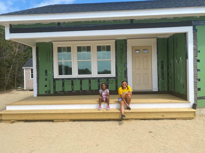 Two girls sitting on porch.