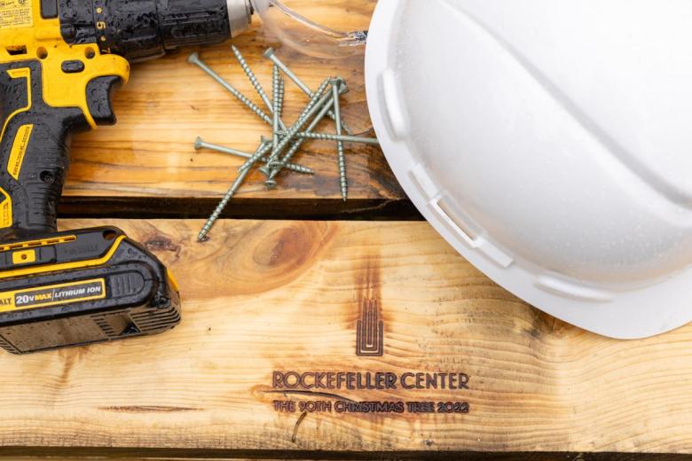 A drill, nails and a hard hat sit on top of lumber from the 2022 Rockefeller Center Christmas tree.