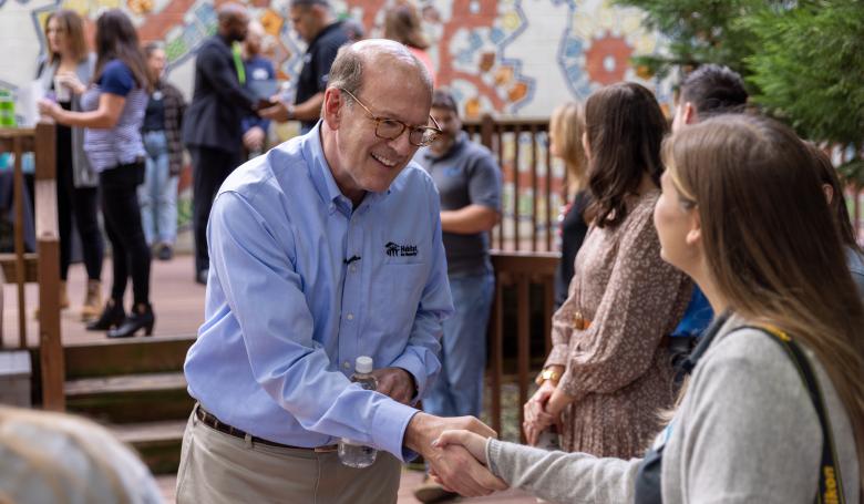 Jonathan Reckford shaking hands with a woman at an event.