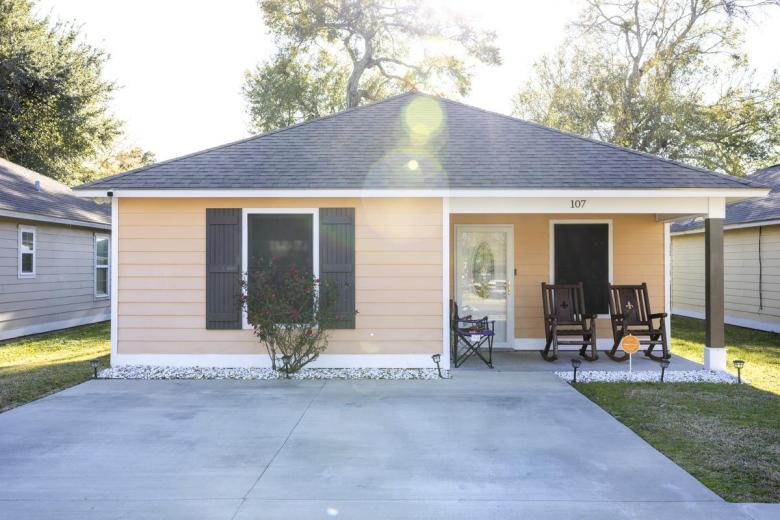 A Habitat home with a patio with rocking chairs.