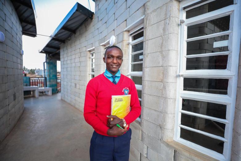 student wearing school uniform outside a classroom