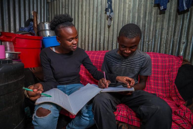 a mother guiding her son through his homework at home